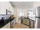 Modern kitchen featuring stainless steel appliances, granite countertops, and white cabinetry at 217 Herring St, Davenport, FL 33897