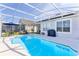 Relaxing backyard pool area with patio furniture and a screened-in enclosure, perfect for outdoor living at 217 Herring St, Davenport, FL 33897