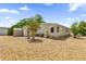 The home has a spacious backyard with gravel landscaping, mature trees and shed for extra storage at 220 Palmer Park Ln, Davenport, FL 33897