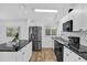 Bright kitchen featuring stainless steel appliances, white cabinetry, and black countertops at 220 Palmer Park Ln, Davenport, FL 33897