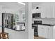 Modern kitchen with stainless steel appliances, ample white cabinetry, and stylish black countertops at 220 Palmer Park Ln, Davenport, FL 33897
