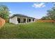 A grassy backyard with a covered patio, perfect for relaxing or entertaining, is surrounded by a wood fence at 2306 Hargill Dr, Orlando, FL 32806