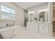 Elegant bathroom featuring double sink vanity, standalone tub, and glass enclosed shower at 2306 Hargill Dr, Orlando, FL 32806