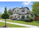 Inviting two-story home with a modern wood garage door, manicured lawn, and lush landscaping at 2306 Hargill Dr, Orlando, FL 32806