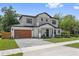 Attractive two-story home with a modern wood garage door, stone driveway, and manicured lawn at 2306 Hargill Dr, Orlando, FL 32806