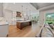 Bright kitchen with white cabinets, large island, and open dining area and hardwood floors at 2306 Hargill Dr, Orlando, FL 32806