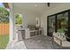 Outdoor kitchen area with stainless steel grill, built-in refrigerator, and gray tile flooring at 2306 Hargill Dr, Orlando, FL 32806