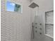 Modern shower with gray wave tile, shower bench, rainfall shower head and multiple massage jets at 2306 Hargill Dr, Orlando, FL 32806