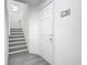 Bright hallway with a staircase and a white door, creating a clean and modern entryway at 2329 Shadow View Cir # 2329, Maitland, FL 32751