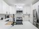 Modern kitchen features white cabinets, stainless steel appliances, quartz countertops and a sink with black faucet at 2329 Shadow View Cir # 2329, Maitland, FL 32751