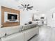 Modern living room featuring a large TV, a gray sofa, and a view into the open-concept kitchen at 2329 Shadow View Cir # 2329, Maitland, FL 32751