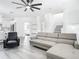 Modern living room with a comfortable gray sofa, staircase, and a view into the kitchen at 2329 Shadow View Cir # 2329, Maitland, FL 32751