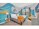 Bright bedroom with a wave mural, comfortable bed, and natural light from the window at 235 Villa Domani Cir, Davenport, FL 33896