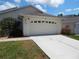 A close up of the garage and driveway with nice landscaping at 236 Ridge View Dr, Davenport, FL 33837