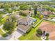 Aerial view of a home with a pool, solar panels, fenced yard, lush greenery and a well-maintained landscape at 239 Longhirst Loop, Ocoee, FL 34761