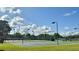 Community basketball court and tennis courts surrounded by lush landscaping and lighting for evening games at 239 Longhirst Loop, Ocoee, FL 34761