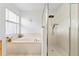 Bright bathroom featuring a luxurious, oversized soaking tub with glass enclosed shower at 239 Longhirst Loop, Ocoee, FL 34761