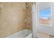 Bright bathroom features a shower and bathtub combo, with tile walls and a window at 239 Longhirst Loop, Ocoee, FL 34761