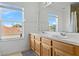Bathroom with double sinks, light wood cabinets, and natural light from a large window at 239 Longhirst Loop, Ocoee, FL 34761