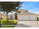 Charming two-story home featuring a three-car garage, manicured lawn, and mature landscaping at 239 Longhirst Loop, Ocoee, FL 34761