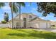 Beautiful exterior view of home, showcasing lush lawn and mature trees at 239 Longhirst Loop, Ocoee, FL 34761