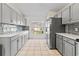 Bright eat-in kitchen boasts gray cabinets, stainless steel appliances, and white countertops at 239 Longhirst Loop, Ocoee, FL 34761