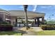 Community pool entrance, featuring covered patio area and tropical landscaping at 239 Longhirst Loop, Ocoee, FL 34761