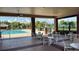 Outdoor community pool with tables and chairs under a covered patio with ceiling fans overlooking tennis courts at 239 Longhirst Loop, Ocoee, FL 34761