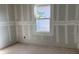 Unfinished bedroom featuring newly installed drywall and a bright, modern window at 2395 Zuni Road, St Cloud, FL 34771