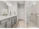 Well-lit bathroom with a double vanity, tiled shower, and neutral color palette at 2457 Cliff Way, St Cloud, FL 34771