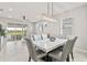 Dining room featuring a modern chandelier and a marble table, adjacent to a screened patio with lake view at 2457 Cliff Way, St Cloud, FL 34771