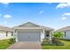 Home featuring a brick paver driveway leading up to a two-car garage and a neatly landscaped garden at 2457 Cliff Way, St Cloud, FL 34771