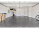 Spacious two car garage with speckled epoxy flooring, storage shelving, and white block walls at 2457 Cliff Way, St Cloud, FL 34771