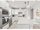 Bright kitchen features white cabinetry, stainless steel appliances, and a large center island with pendant lighting at 2457 Cliff Way, St Cloud, FL 34771