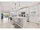 Open-concept kitchen with white cabinets, stainless steel appliances, and island seating, flowing into dining area at 2457 Cliff Way, St Cloud, FL 34771