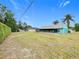 Spacious backyard featuring a screened lanai, mature trees, and a verdant lawn at 2558 Academy Ave, Deltona, FL 32738