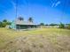 Expansive backyard with a screened-in patio, bordered by privacy hedging and mature landscaping at 2558 Academy Ave, Deltona, FL 32738