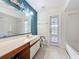 Bathroom with teal accent wall, white cabinets, and tub shower at 2558 Academy Ave, Deltona, FL 32738