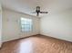 Bright bedroom features a ceiling fan, wood-look floors, and a window for natural light at 2558 Academy Ave, Deltona, FL 32738
