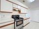 Updated kitchen featuring stainless steel range and white cabinets for a modern look at 2558 Academy Ave, Deltona, FL 32738