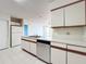 Kitchen view highlighting stainless steel appliances, white cabinetry, and double-basin sink at 2558 Academy Ave, Deltona, FL 32738