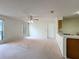 Bright living room with carpeted floor, ceiling fan, and view of the kitchen area at 2558 Academy Ave, Deltona, FL 32738