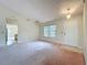 Cozy front living room with a view to the kitchen featuring a front door and large window at 2558 Academy Ave, Deltona, FL 32738