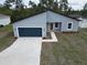 Charming single-story home with a blue garage door, landscaped yard, and modern architectural design at 2644 Sw 162 Nd Street Rd, Ocala, FL 34473