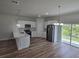Eat-in kitchen with stainless steel appliances, white cabinets, and modern vinyl plank flooring at 2644 Sw 162 Nd Street Rd, Ocala, FL 34473