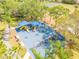 Community playground with slides, swings, and covered play areas surrounded by lush trees at 2844 Eagle Lake Dr, Orlando, FL 32837
