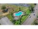 Aerial view shows community pool with lounge chairs and landscaping near a lake at 3192 Running Deer Path, Kissimmee, FL 34746
