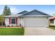 Charming single-story home with a two-car garage, red shutters, and well-manicured front lawn at 3192 Running Deer Path, Kissimmee, FL 34746
