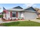 Charming single-story home with a two-car garage, red shutters, and well-manicured front lawn at 3192 Running Deer Path, Kissimmee, FL 34746