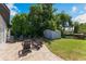 Backyard patio area with paver tiles, surrounded by mature trees and a small storage shed for outdoor convenience at 3204 Tradewinds Trl, Orlando, FL 32805